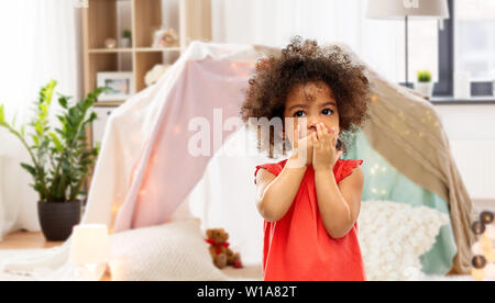 confused african american girl covering mouth Stock Photo