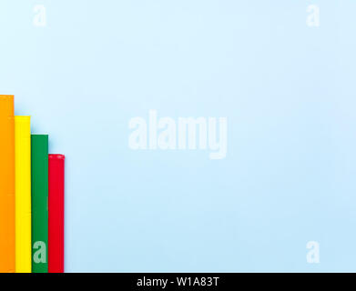 Bar chart made from colorful notebooks on light blue background with empty space for text. Stock Photo