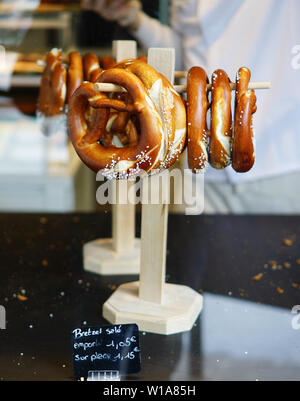 Pretzel on wooden stand on black table Stock Photo