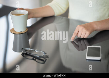 woman with coffee using black interactive panel Stock Photo