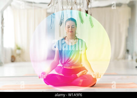 woman meditating in lotus pose at yoga studio Stock Photo