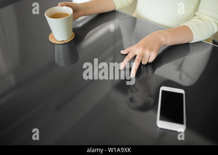 woman with coffee using black interactive panel Stock Photo