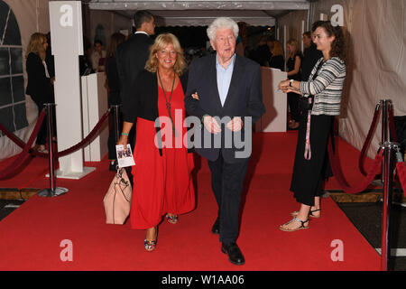 Munich, Germany. 27th June, 2019. The choir director Gotthilf Fischer and his manager Esther Müller walk over the red carpet of the Audi Director's Cut and the industry meeting Movie Meets Media at the Filmfest Munich which takes place from 27.06.2019 to 06.07.2019. Credit: Felix Hörhager/dpa/Alamy Live News Stock Photo