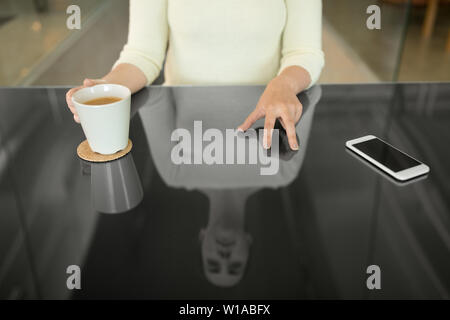 woman with coffee using black interactive panel Stock Photo