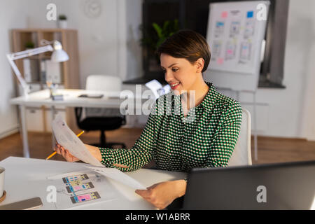 woman working on user interface at night office Stock Photo