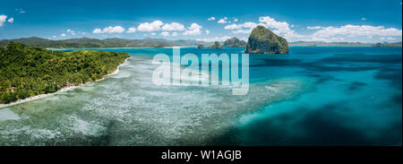 Aerial stunning panorama of turquoise sea water, magnificent limestone cliffs and tropical sea shore n El Nido, Palawan, Philippines. Stock Photo