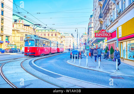 VIENNA, AUSTRIA - FEBRUARY 18, 2019: The urban scene with red retro style tram rides along the central Karntner Strasse with Vienna State Opera on the Stock Photo