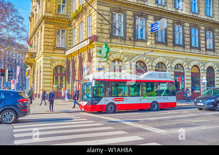 VIENNA, AUSTRIA - FEBRUARY 18, 2019: The small modern electric bus with folding poles is the ideal choice for tight streets in historical center, on F Stock Photo