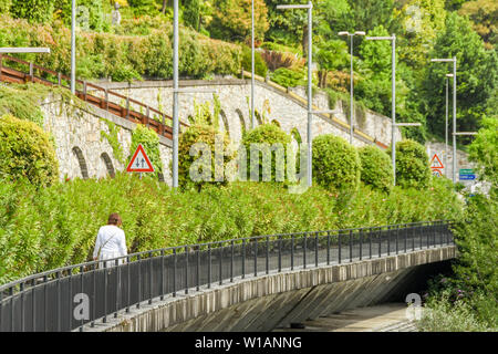 LAKE COMO, ITALY - JUNE 2019: Person  walking near Menaggio on the trail which runs for several miles around Lake Como - the Greenway del Lago di Como Stock Photo