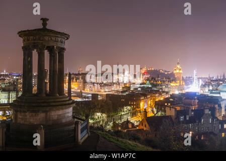 View from Calton Hill with the Dugald Stewart Monument over the historic Old Town with Edinburgh Castle at night, Edinburgh, Scotland, United Kingdom Stock Photo