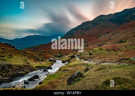 Brook run in autumnal hilly landscape with cloudy sky, Ambleside, Lake District National Park, Middle England, Great Britain Stock Photo