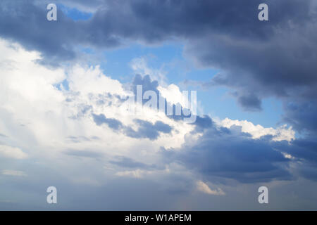White and gray clouds cover the last spot of blue sky before the storm. Dramatic skyscape. Stock Photo