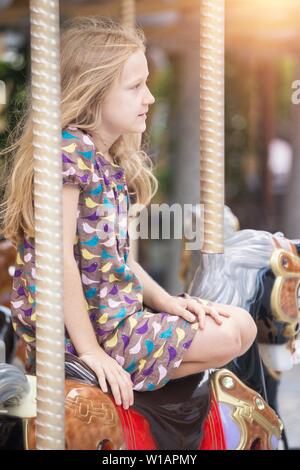 little girl rides a french carousel. Paris. France Stock Photo