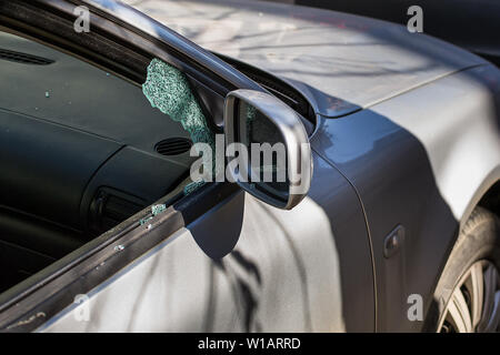 Car window smashed by a thief. Car broken window. Broken right side window of a car parked on the street. Theft from the car. A criminal incident. Hac Stock Photo
