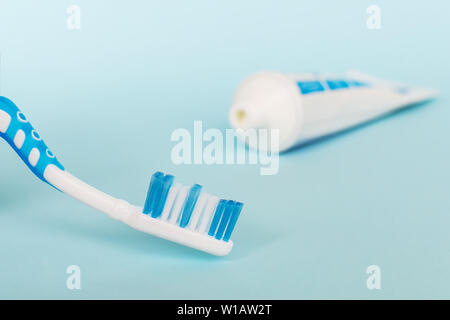 Blue toothbrush and toothpaste on a blue background. The concept of daily dental care Stock Photo