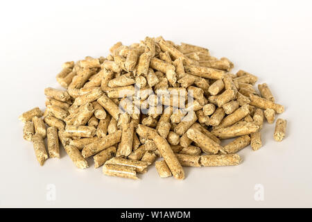 A heap of wooden pellets on white background. Alternative biofuel from sawdust for burning in furnaces and stoves. Cat and hamster litter. Stock Photo