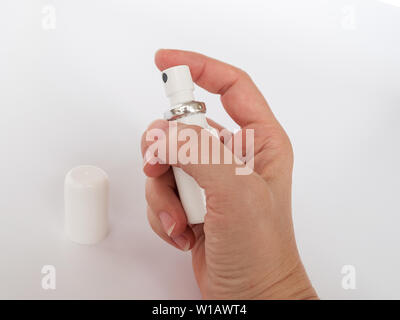 Female hand holding a white medical aerosol can close up. Drug in the form of a spray. Stock Photo