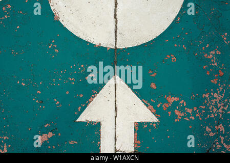 White arrow and circle painted on road. Symmetrical urban road signs on colourful background and grungy texture with crack on asphalt. RF background Stock Photo