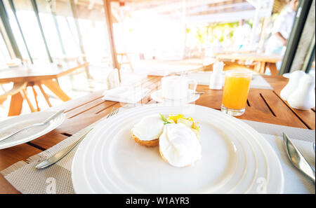 Poached eggs and potato for breakfast in Mauritius luxury resort. Early sunny morning. Toned image. Stock Photo