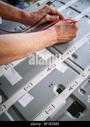 Engineer testing electronic component with voltage meter Stock Photo