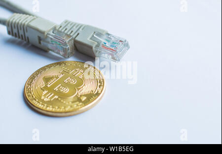 Bitcoin gold coin and network wire connector patch cord cable Stock Photo