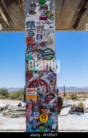 Lots of stickers pasted on a demolished Gas Station on Highway 62, Rice, California, USA Stock Photo