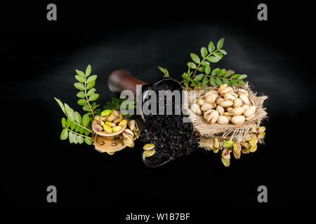 Hookah bowl with tobacco. Pistachio shisha tobacco. On a black background. Stock Photo
