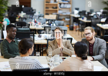 Portrait of cheerful businesswoman wearing glasses smiling happily during meeting in office, copy space Stock Photo