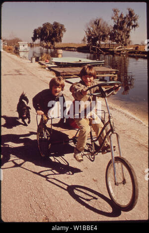 CHILDREN OF FISHERMEN ON HOMEMADE TRICYCLE Stock Photo