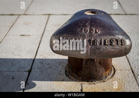 rusty old bollard standing on a stone floor in the harbor of Cres (Croatia) Stock Photo