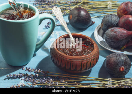 Fig Jam in a Bowl, Fresh Figs, and Cup of Tea on a Wooden Background. Healthy Tasty Breakfast Concept Stock Photo