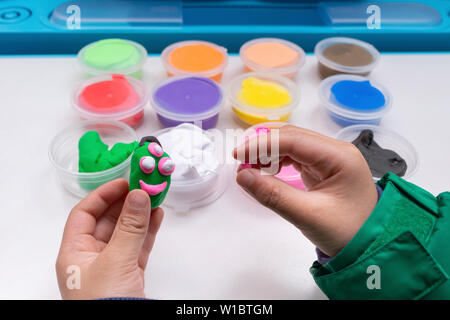 kid playing plasticine and modeling something cute Stock Photo