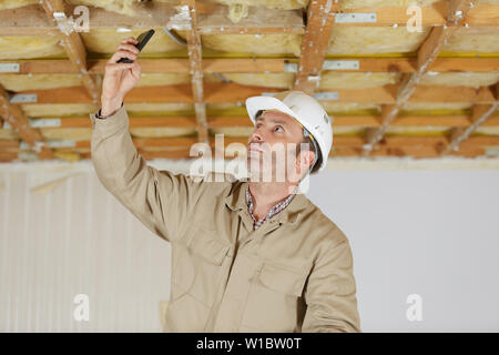 male builder using smartphone to take photograph on site Stock Photo