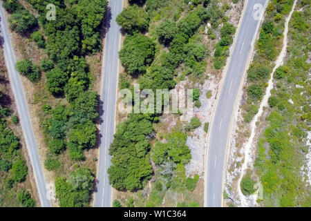 Mountain road surrounded by lush green forest, Aerial image Stock Photo ...