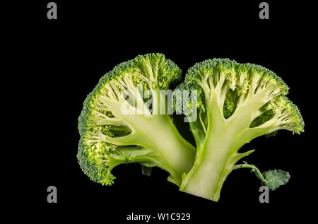 Broccoli florets cut in half on a black background Stock Photo