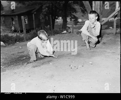 Donald Sergent shooting marbles while a pal looks on. P V & K Coal Company, Clover Gap Mine, Lejunior, Harlan County, Kentucky. Stock Photo