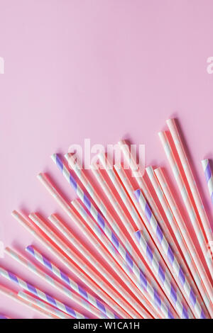 row of drinking straws with stripe and polka dot design border on pink background.prohibition of the use of plastic.Minimalism concept. Pop art style Stock Photo