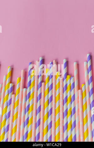 row of drinking straws with stripe and polka dot design border on pink background.prohibition of the use of plastic.Minimalism concept. Pop art style Stock Photo