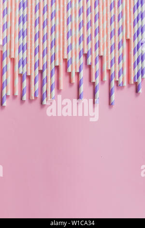 row of drinking straws with stripe and polka dot design border on pink background.prohibition of the use of plastic.Minimalism concept. Pop art style Stock Photo