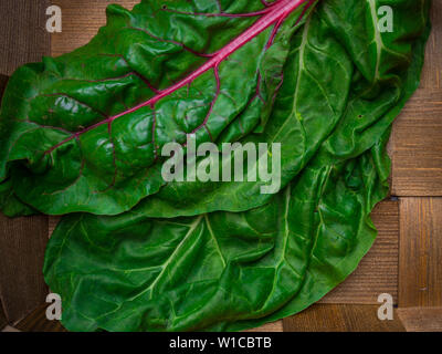 Fresh chard mangold salad leaves in old basket background. Top view. Healthy eating theme, food rich in cellulose Stock Photo