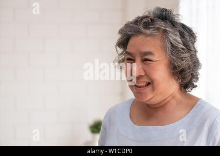 Asian senior woman smile in living room at home,Happy aging at home concept Stock Photo