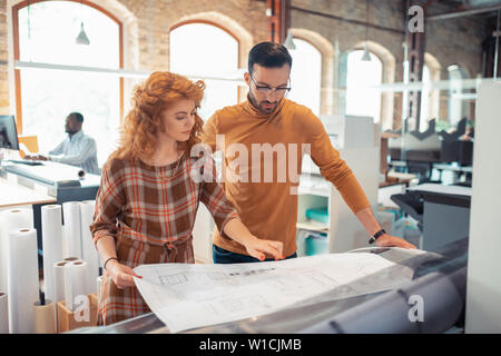 Designers discussing. Two hard-working interior designers discussing new project together Stock Photo