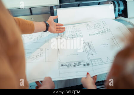 Analyzing sketches. Top view of two talented interior designers analyzing sketches together Stock Photo