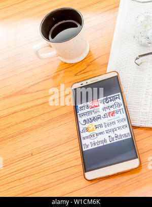 Kolkata, India, February 3, 2019: All bengali newspapers at once visible on mobile phone screen beautifully placed over a wooden table with a newspape Stock Photo