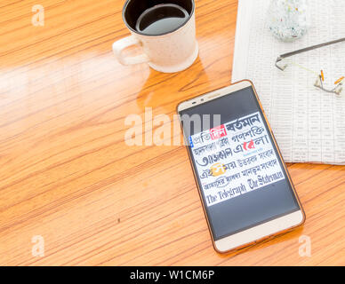 Kolkata, India, February 3, 2019: All bengali newspapers at once visible on mobile phone screen beautifully placed over a wooden table with a newspape Stock Photo