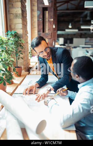 Cooperating on project. Two interior designers feeling cheerful while cooperating on project together Stock Photo