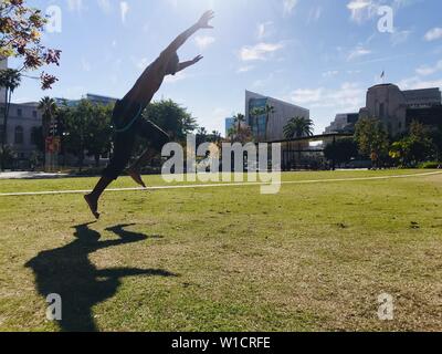 A man uses his lunch break to practice his agility and martial arts moves in the park across from Los Angeles City Hall. Stock Photo