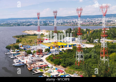 High-voltage power line truss poles mounted on the Varna lake shore. Photo taken from Asparuhov Bridge, Varna, Bulgaria Stock Photo