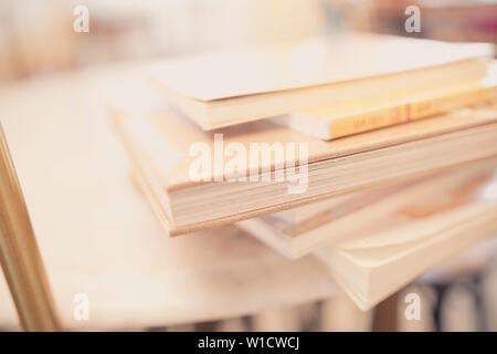 close up books stacking on table in room and warm light Stock Photo