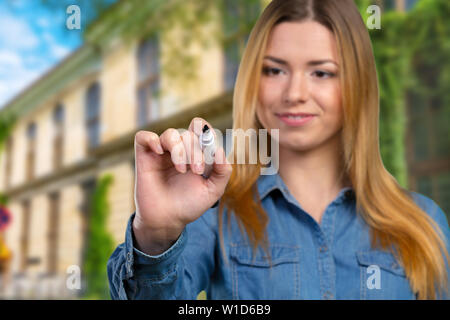 Happy smiling cheerful young business woman writing or drawing on screen Stock Photo